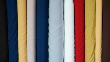 various types of rolled colorful fabrics neatly arranged for the background photo