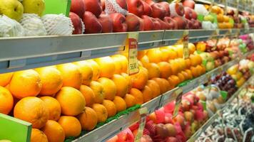 varios tipos de frutas tal nosotros naranja, manzana, pera, arreglado y monitor en estantería o estante son vendido en supermercados foto