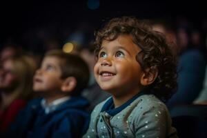 A wide eyed little boy gazes with wonder at the stage during his first theater visit photo
