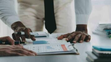 Group of confident business people point to graphs and charts to analyze market data, balance sheet, account, net profit to plan new sales strategies to increase production capacity. video