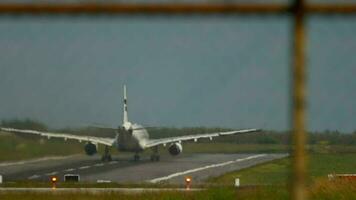 Slow motion footage of an airplane taking off, haze on the airfield. View through the fence video