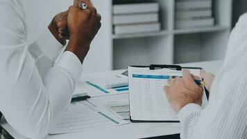 Group of confident business people point to graphs and charts to analyze market data, balance sheet, account, net profit to plan new sales strategies to increase production capacity. video