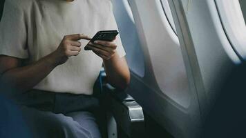 reser och teknologi. flygande på först klass. Söt ung företagare kvinna använder sig av smartphone medan Sammanträde i flygplan. video