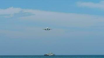 passagerare jet flygplan närmar sig innan landning. flygplan flugor över blå hav. Yacht, fartyg eller fiske trålare i de bakgrund. flyg begrepp video