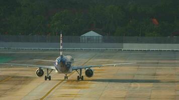 Airplane taxiing on the airfield, rear view. Air carrier on taxiway. Palm tree background video