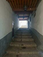 Narrow driveway under a beautiful wooden roof and between pretty houses photo