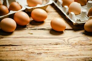 Chicken eggs on wooden table. photo