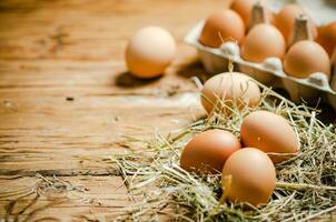 Chicken eggs on wooden table. photo