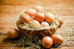 Chicken eggs in a plate on wooden table. photo