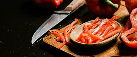 Chopped sweet pepper. On black table. photo