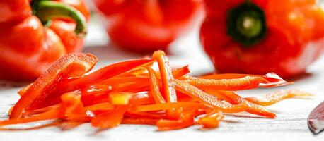 Chopped sweet pepper. On white table. photo