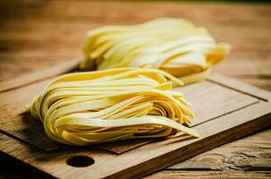 Homemade pasta tagliatelle. On wooden table. photo