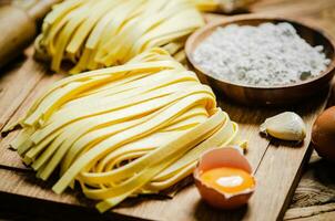 Homemade pasta tagliatelle. On wooden table. photo