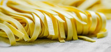 Homemade pasta tagliatelle. On white table. photo