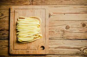 hecho en casa pasta tallarines. en de madera mesa. foto