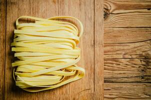 hecho en casa pasta tallarines. en de madera mesa. foto