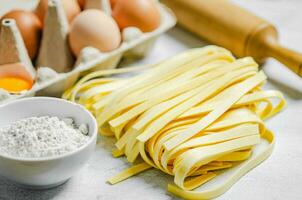 Homemade pasta tagliatelle. On white table. photo