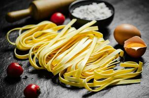 Homemade pasta tagliatelle. On black table. photo