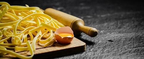 Homemade pasta tagliatelle. On black table. photo