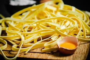 Homemade pasta tagliatelle. On wooden table. photo