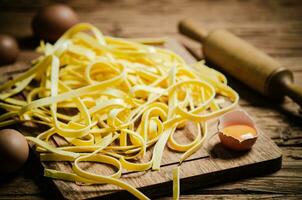Homemade pasta tagliatelle. On wooden table. photo