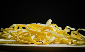 Homemade pasta tagliatelle. On wooden table. photo