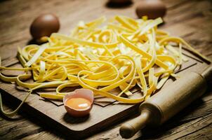 Homemade pasta tagliatelle. On wooden table. photo