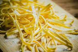 Homemade pasta tagliatelle. On wooden table. photo