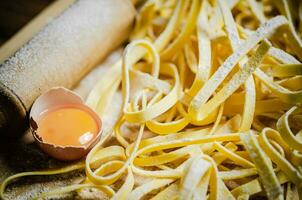 Homemade pasta tagliatelle. On wooden table. photo