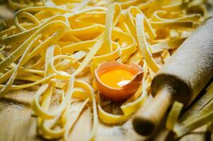 Homemade pasta tagliatelle. On wooden table. photo