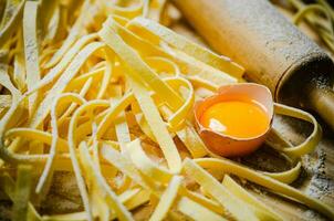 Homemade pasta tagliatelle. On wooden table. photo