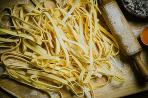 Homemade pasta tagliatelle. On wooden table. photo