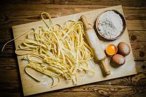 Homemade pasta tagliatelle. On wooden table. photo