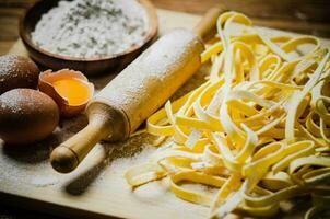 Homemade pasta tagliatelle. On wooden table. photo