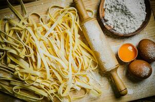 Homemade pasta tagliatelle. On wooden table. photo