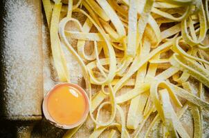 Homemade pasta tagliatelle. On wooden table. photo