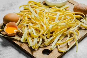 Homemade pasta tagliatelle. On white table. photo