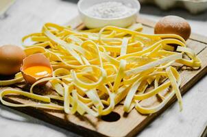 Homemade pasta tagliatelle. On white table. photo