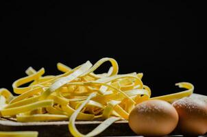 Homemade pasta tagliatelle. On black table. photo