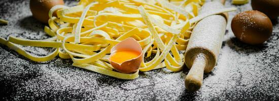 Homemade pasta tagliatelle. On black table. photo