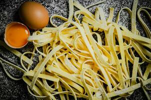 Homemade pasta tagliatelle. On black table. photo