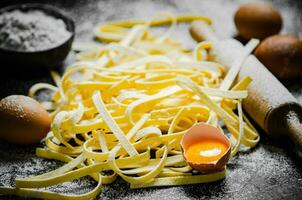 Homemade pasta tagliatelle. On black table. photo