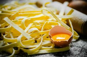 Homemade pasta tagliatelle. On black table. photo