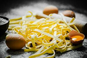 Homemade pasta tagliatelle. On black table. photo