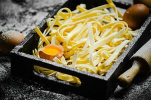 Homemade pasta tagliatelle. On black table. photo