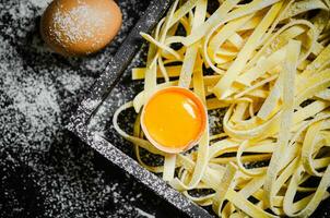 Homemade pasta tagliatelle. On black table. photo