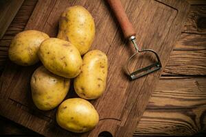 Fresh potatoes. On wooden table. photo