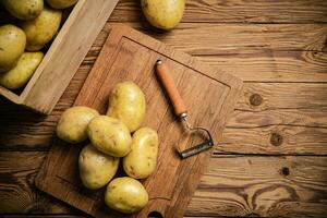 Fresh potatoes. On wooden table. photo