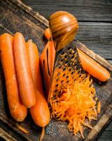 Grated carrots on a cutting Board with a grater. photo