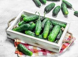 Cucumbers on a wooden tray with a napkin. photo